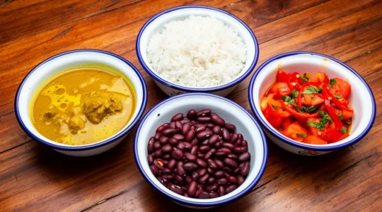 Table traditionnelle créole avec cari, riz, grains et rougail disposés dans l'ordre traditionnel de service