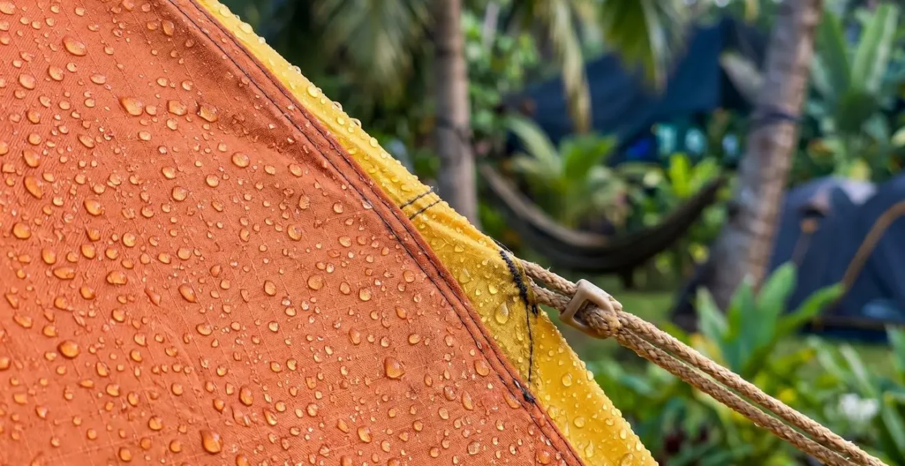 Jardin tropical luxuriant avec tentes de camping colorées installées sous les palmiers